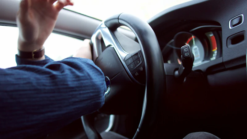 A driver holding a steering wheel, where the front airbag sits